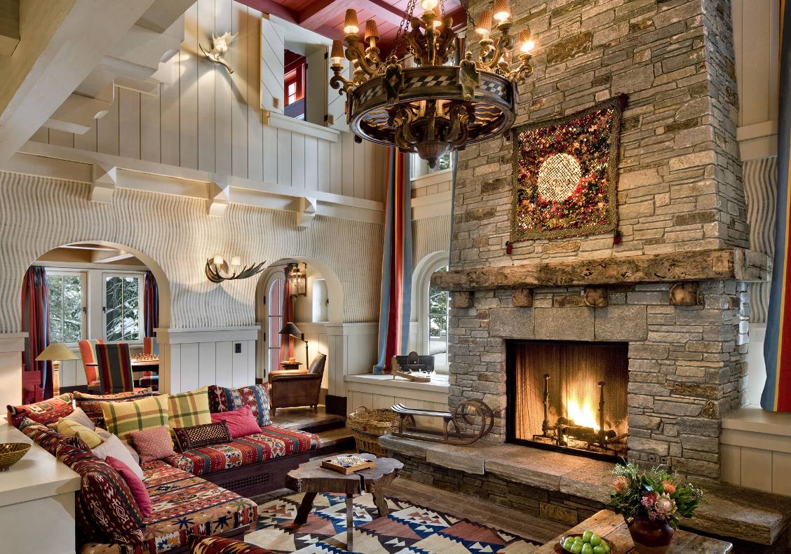 Soaring two story great room with stone fireplace, arched openings to game room, restored french chandelier.