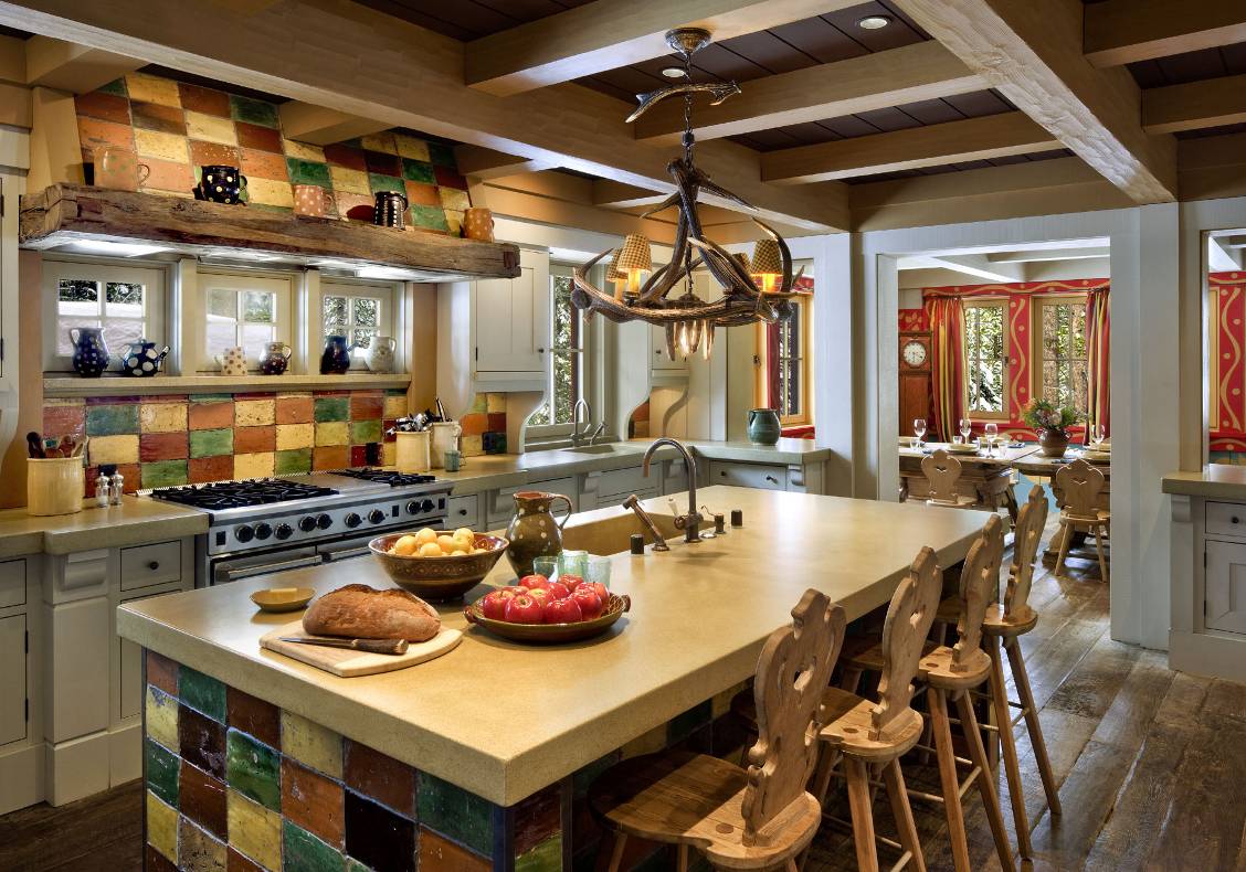 View of kitchen with reclaimed 18th century tiles, concrete counter, Swiss wooden stools.
