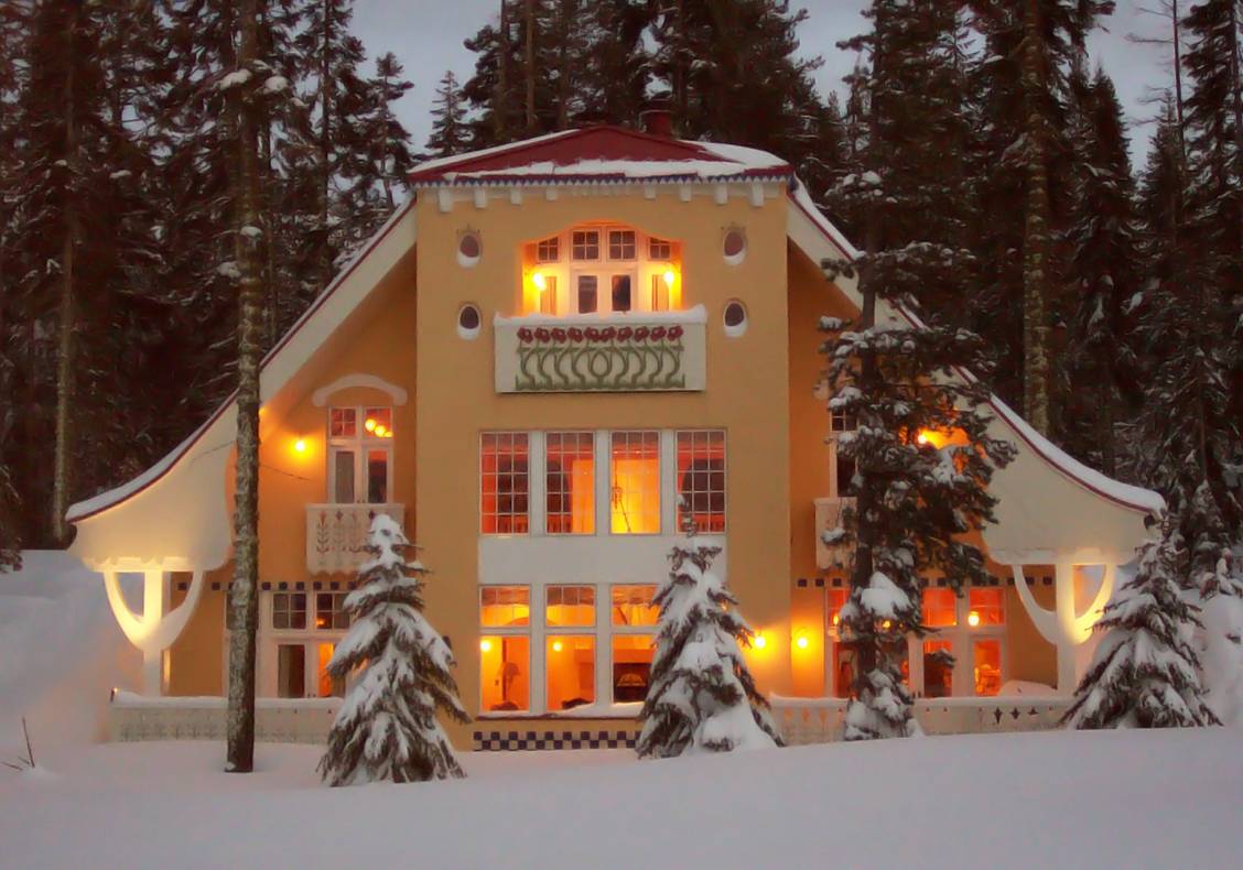 Exterior of this mountain home glows through the fresh evening snowfall