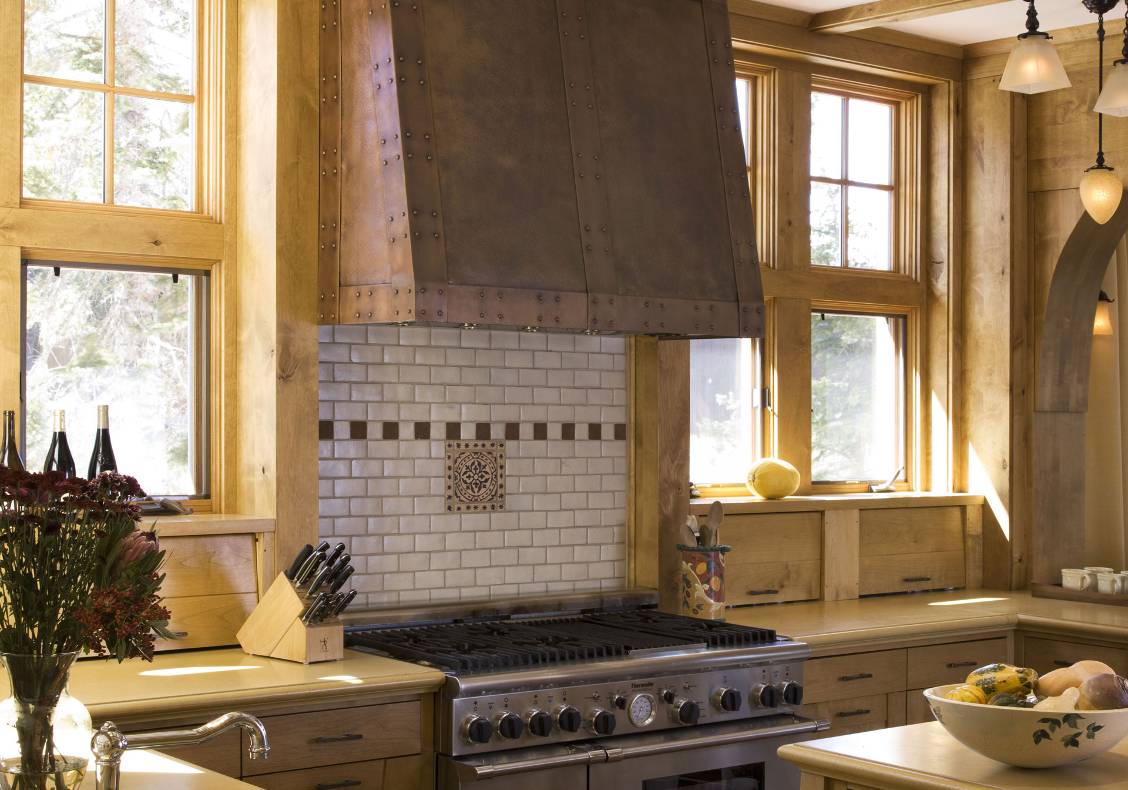 Custom designed hammered copper hood is the centerpiece of the kitchen, framed by large windows looking out to the ski slopes at Sugar Bowl Ski Resort.