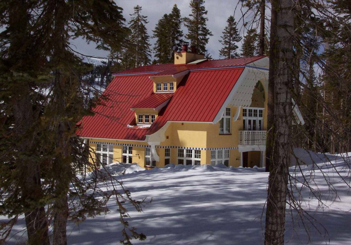 Gambrel or double sloping roof shield the exterior of this home from snow.  Stepping dormer windows provide views from the stair at the upper levels of this cheerful home.