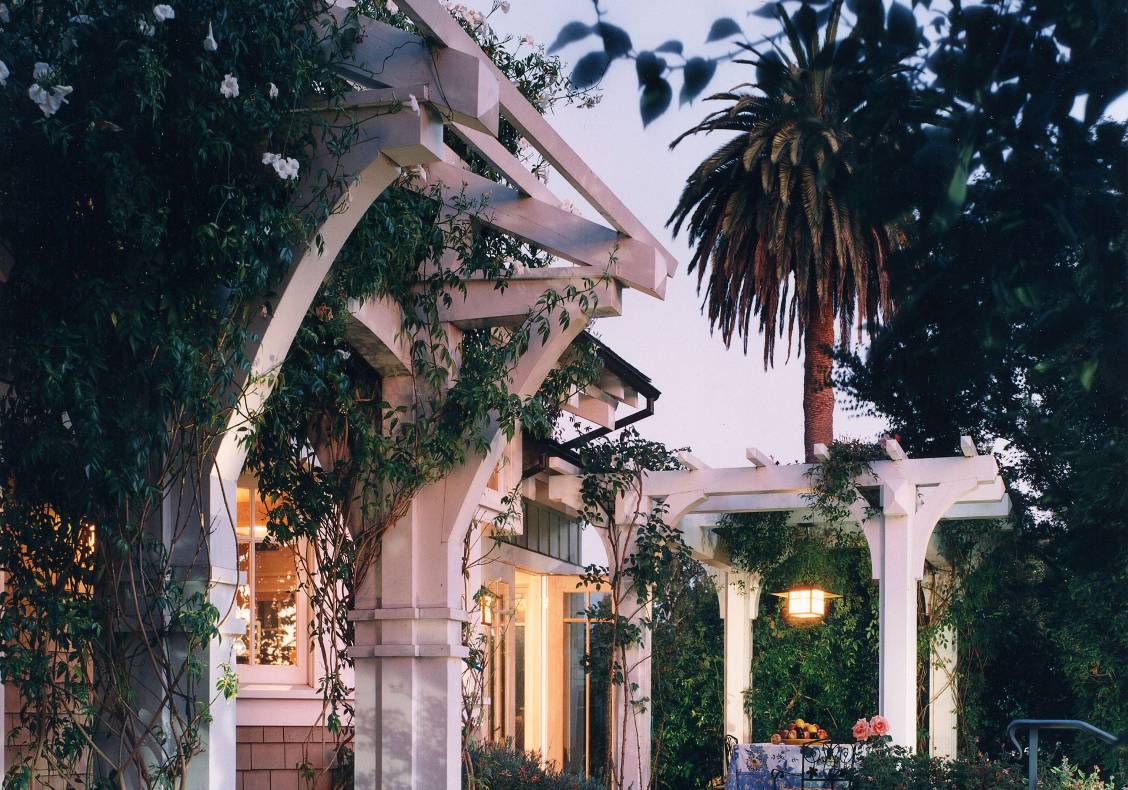 The pergola at the entry is covered with fragrant jazmine and white roses.