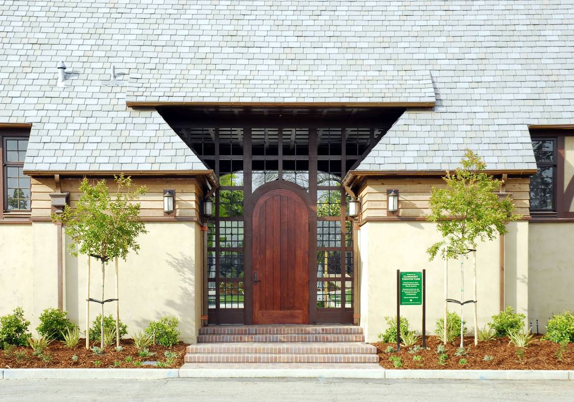 Blending both traditional and modern detailing, this simple wood plank door surrounded by glazing marks one of the entrances to the country club's new Aquatic Center.