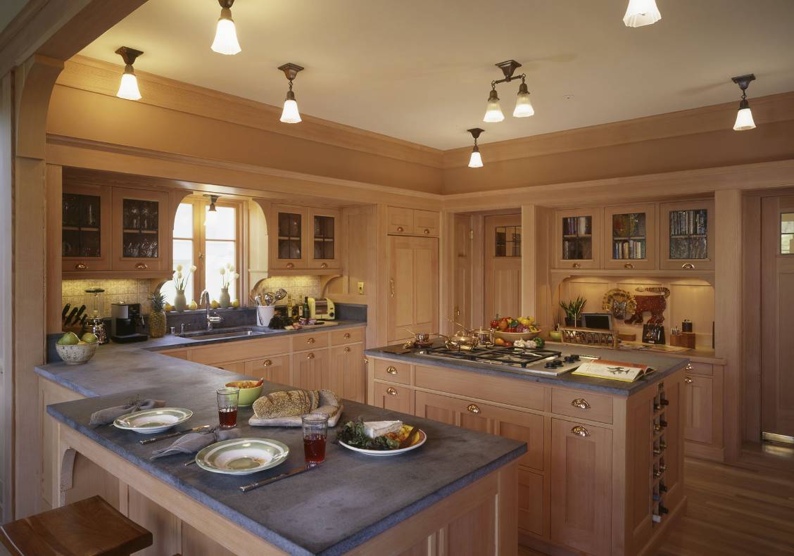 Soapstone counters and ceiling-mounted light fixtures; cabinet doors are fitted with seeded glass set in lead frames.
