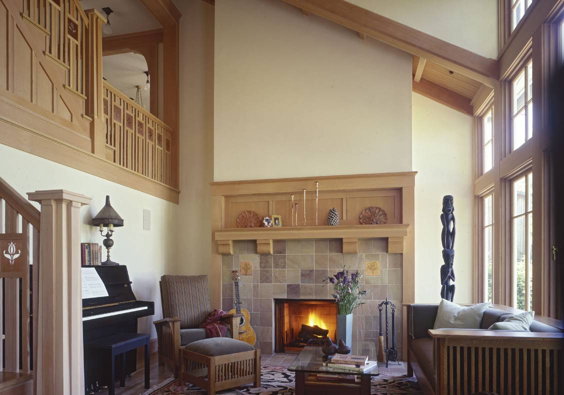 The soaring living room  faces a rear terrace and has a dramatic overlook from the entry hall.