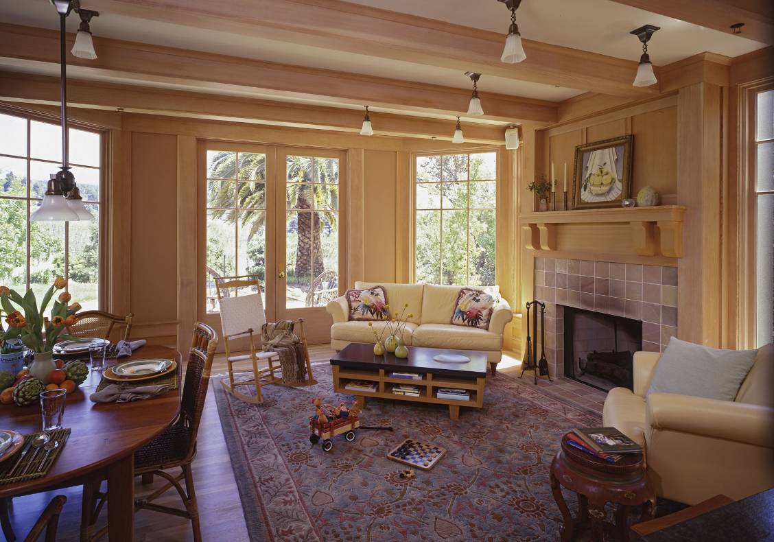 Informal family room opens to a terrace and incorporates heavy timber shaped brackets at the fireplace mantel.