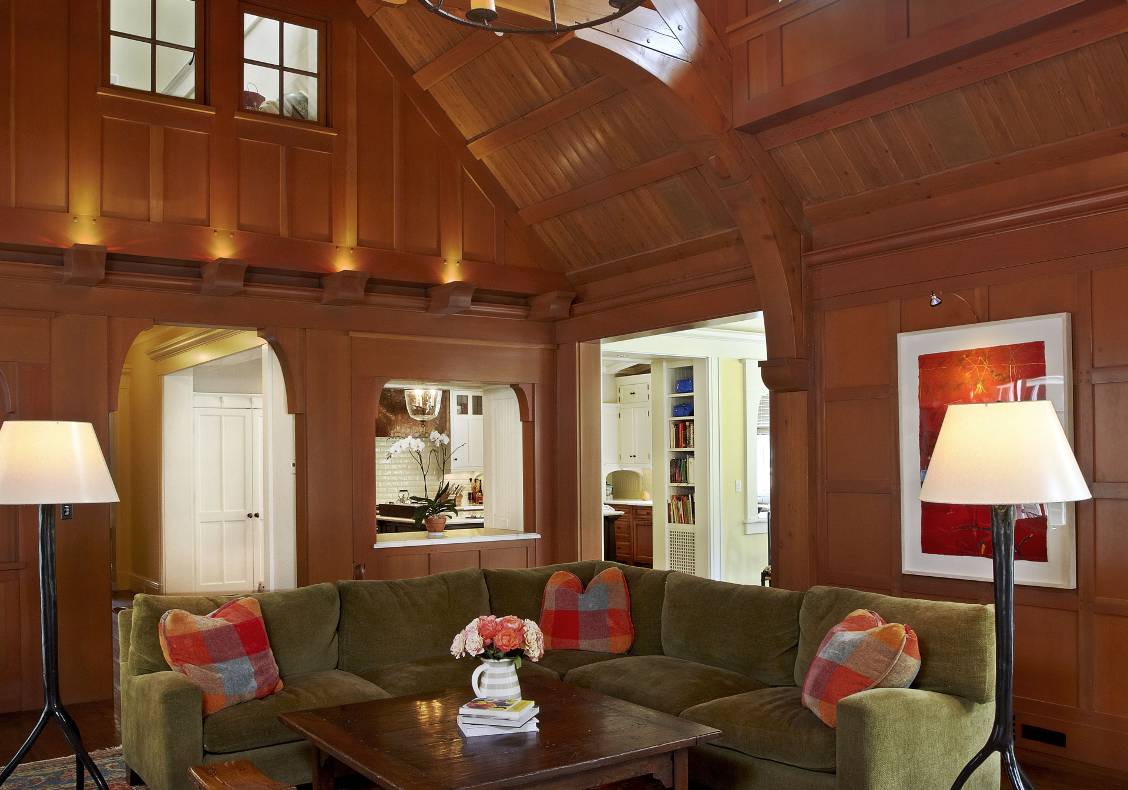 English country manor great room view to kitchen, with heavy timber trusses, clearstory windows,  stained douglas fir millwork, overlook from children's room above.