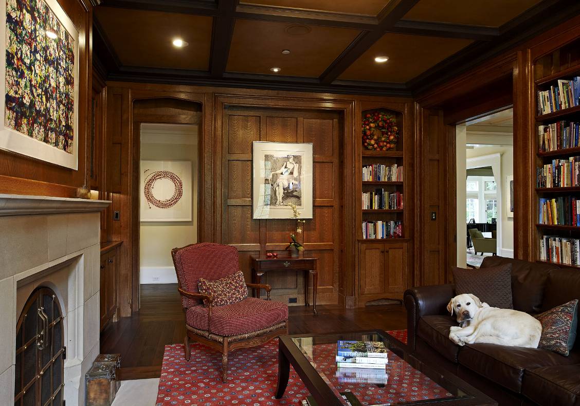 English country manor oak library with cast stone Lutyens fireplace surround, bronze fireplace doors, and leather ceiling.