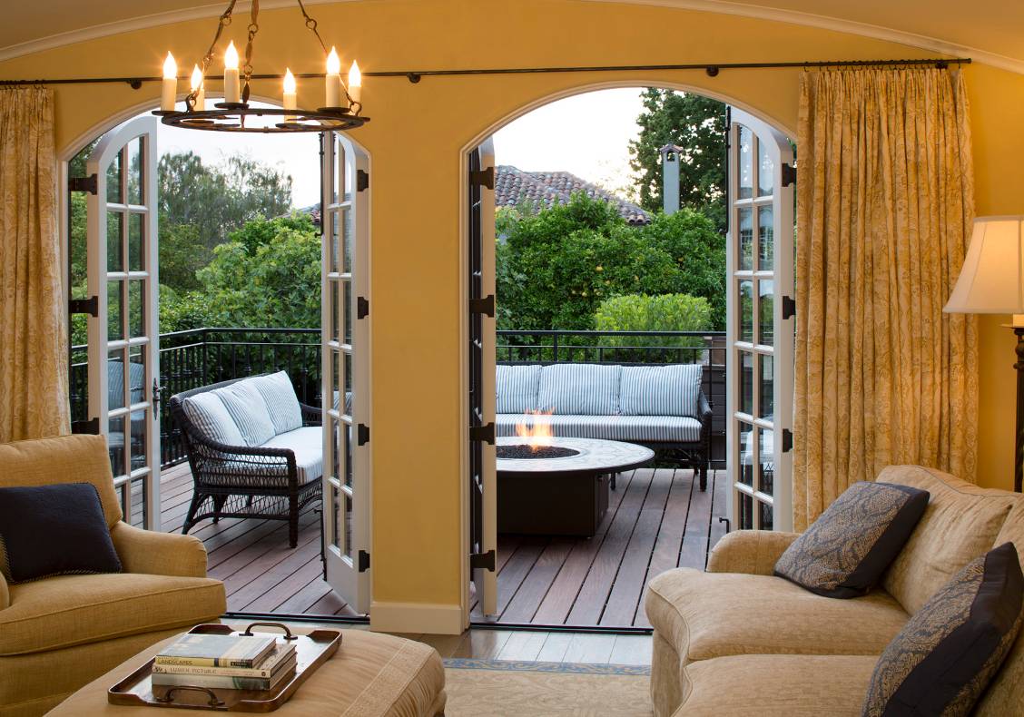 The new deck overlooking the backyard features a central fire table with a mosaic top.