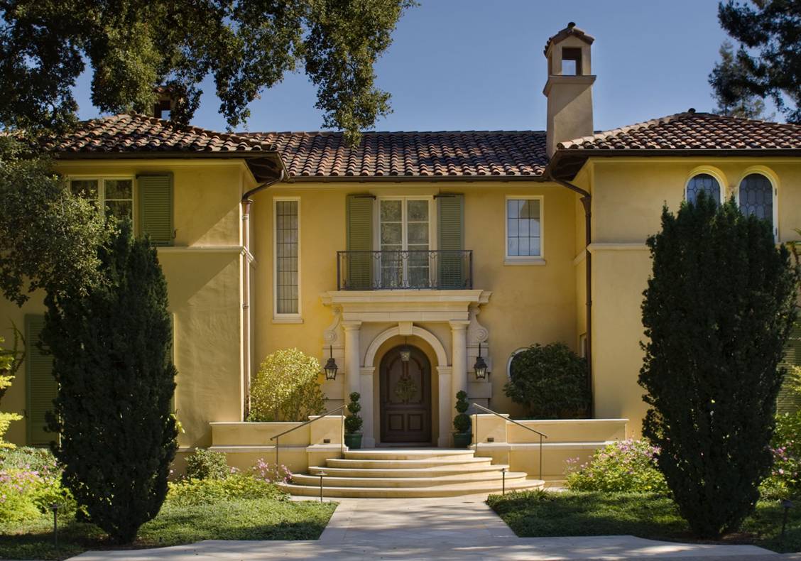 Curved stairs lead from the driveway to the front portal.