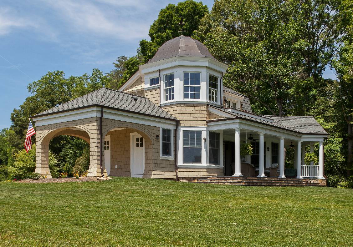 The spacious, east-facing porch is an outdoor living room that spills its bluestone steps literally onto the broad, grassy slope leading to the water’s edge.