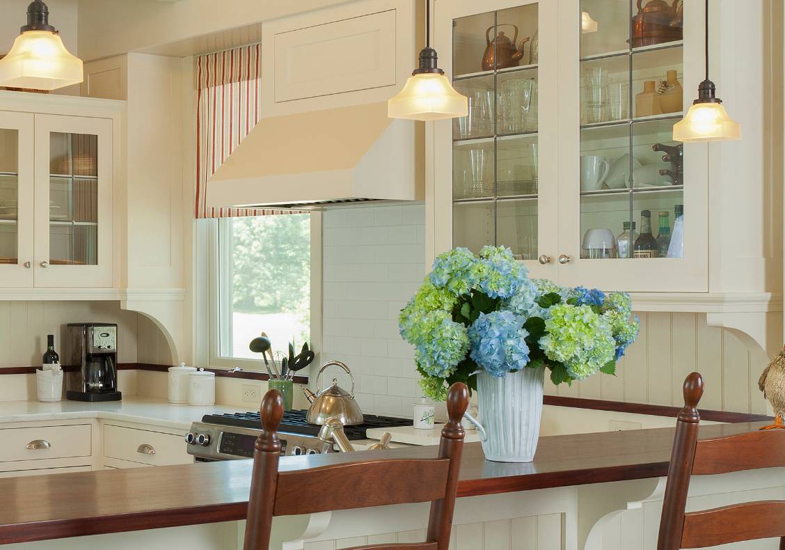 The leaded glass windows of the upper cabinets and the scalloped brackets make this simple kitchen special.