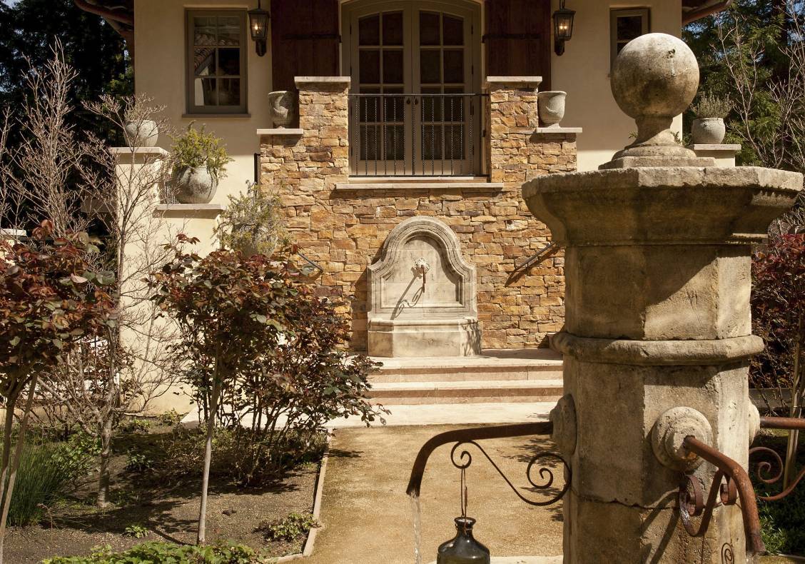 The house is a symphony of rich stones and textures: scraped hickory pegged floors, carved limestone fireplaces, antique marble fountains, and hand-wrought iron stair railings.
