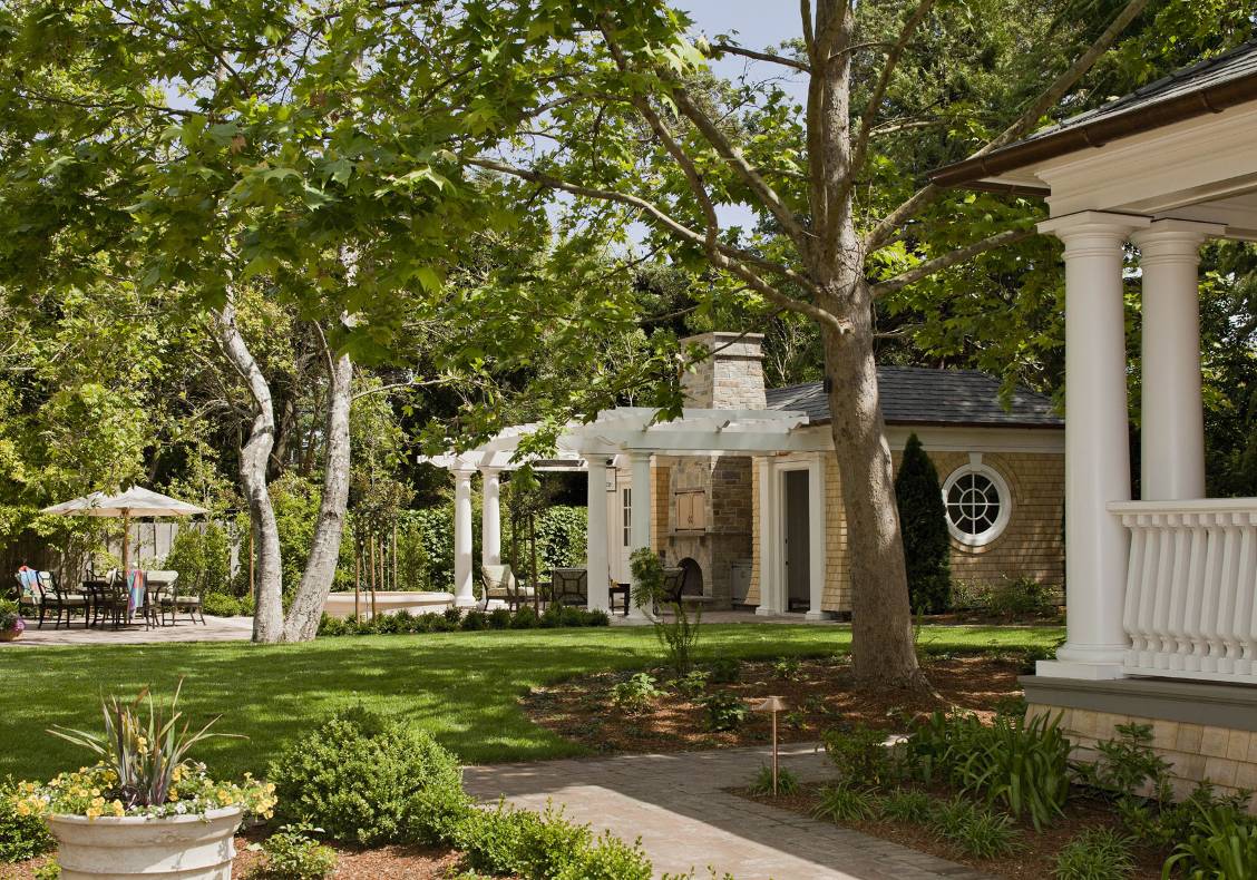 Strategically located to maximize the large lawn, a new pool house doubles as an exercise room and guest cottage complete with a Murphy bed. An outdoor family room is created with the trellis, stone fireplace, and spa next to the pool.
