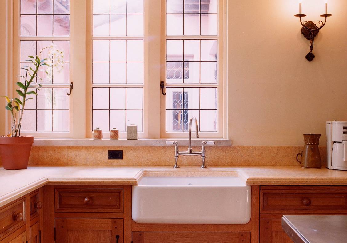 Behind the sink, a row of windows provides a view of the kitchen courtyard.