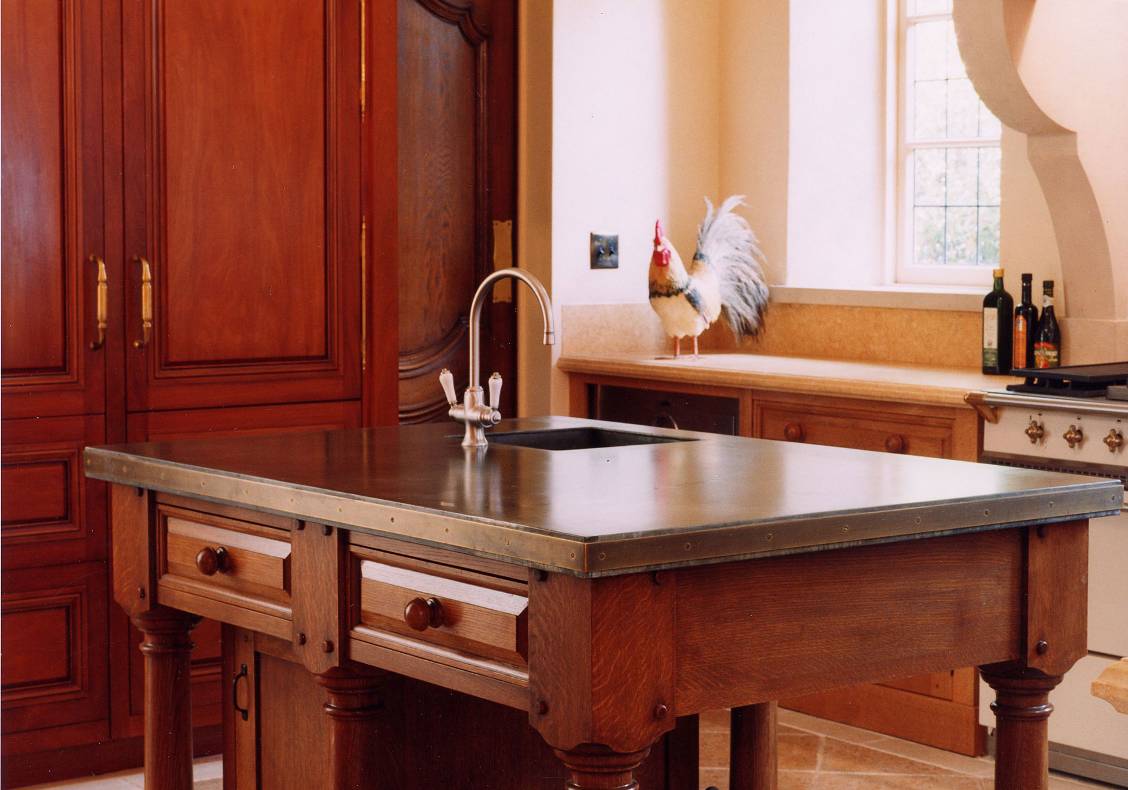 The kitchen island is designed to appear as a piece of free-standing furniture.