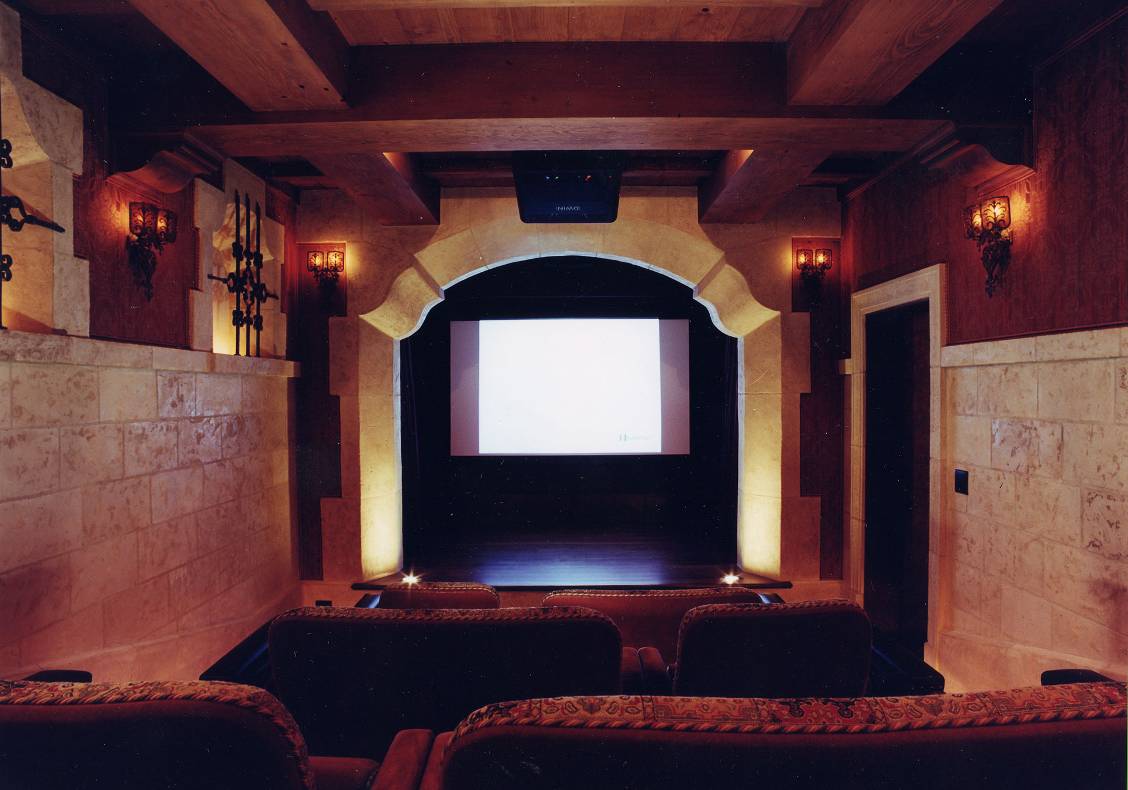 A new media room tucked under the garage resembles a traditional theatre with stage, proscenium, upholstered seats, and hand painted beamed ceiling inspired by the Basilica of Assisi.