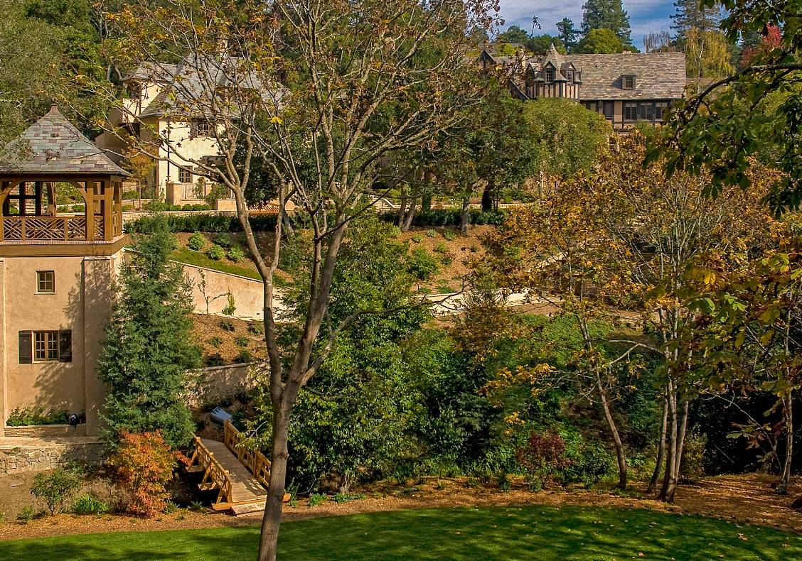 Perched like a tree house, the gazebo has beautiful, sylvan views of a brook, bridge, pool, and sport court.