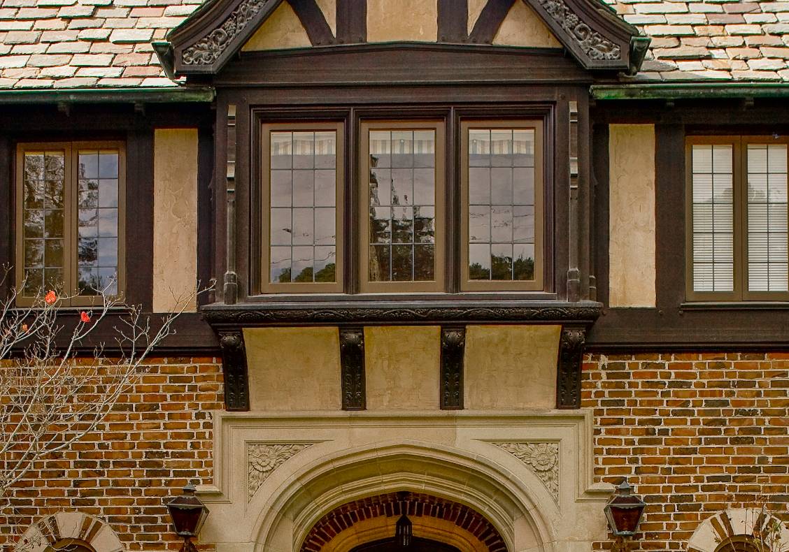 The magnificent carved stone entry portal draws the visitor inside, and blends harmoniously with the surrounding brick and timber-framed bay windows above.