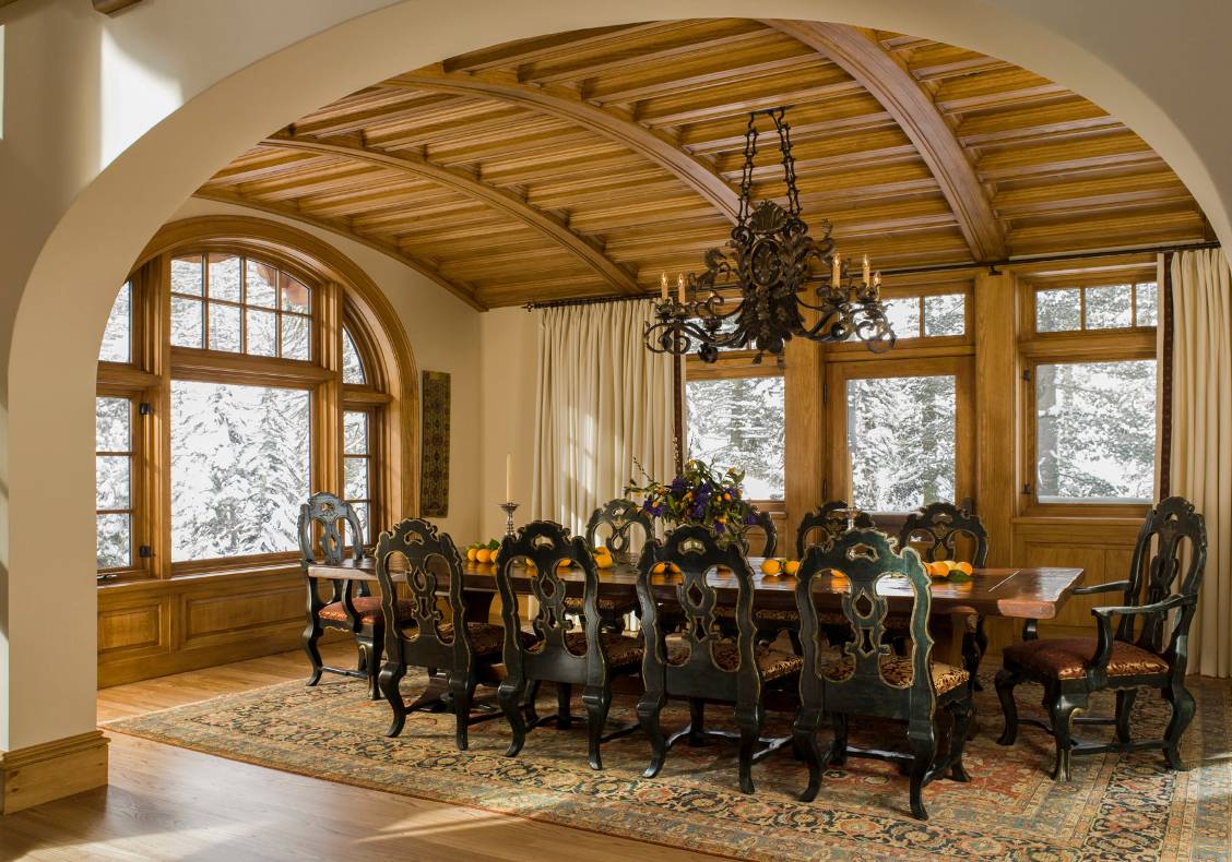 Under a pine barrel vault, the dining room opens into the main space and enjoys a cheerful view of the fireplace.