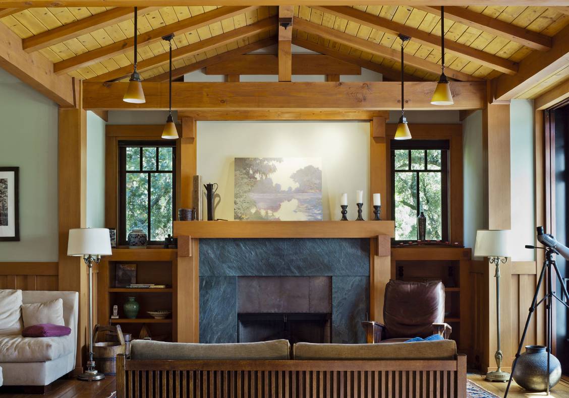 The fireplace is surrounded by black Soapstone slab, encased by a stained wood mantel with brackets, and build-in bookcases.